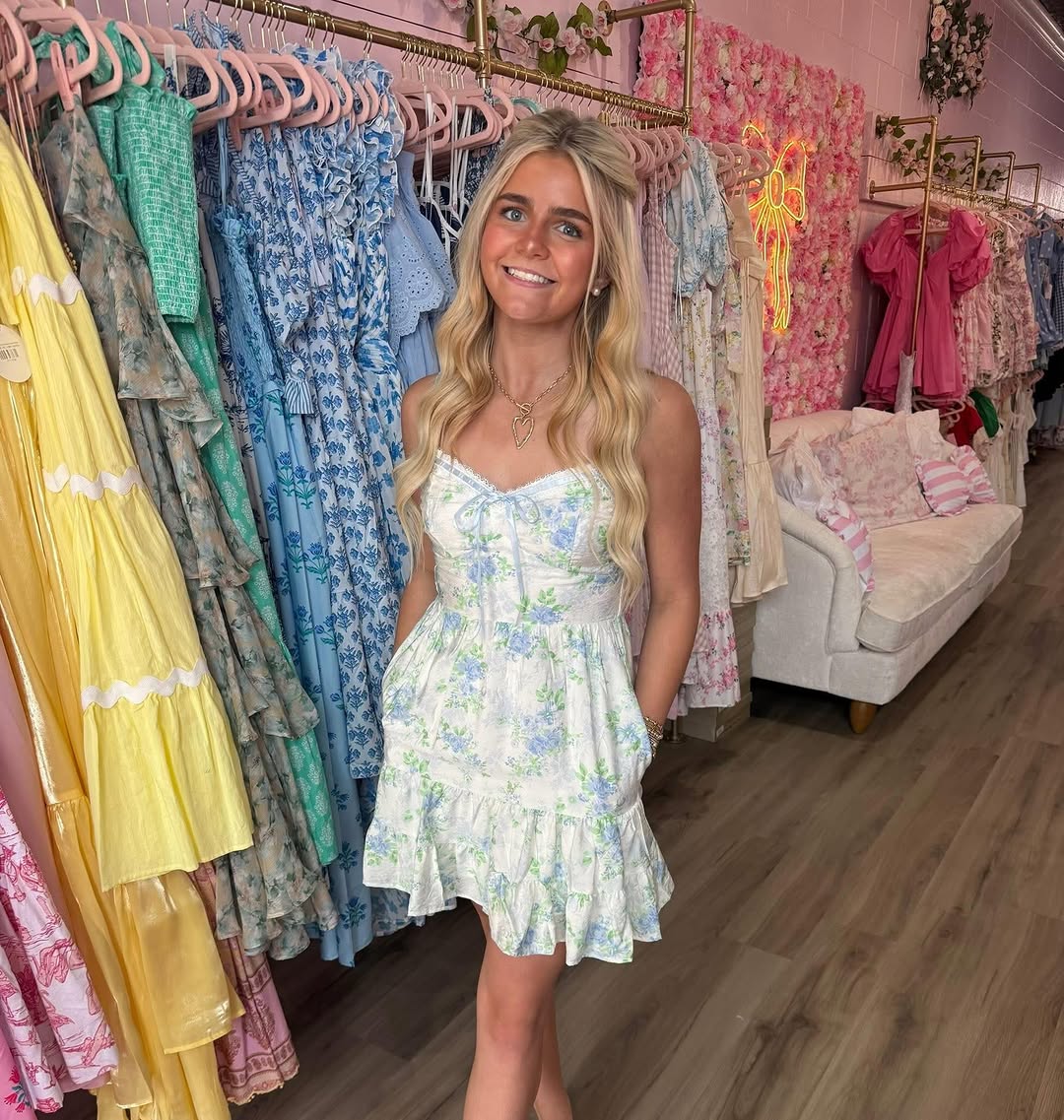 A row of pastel sundresses on chrome-pink hangers