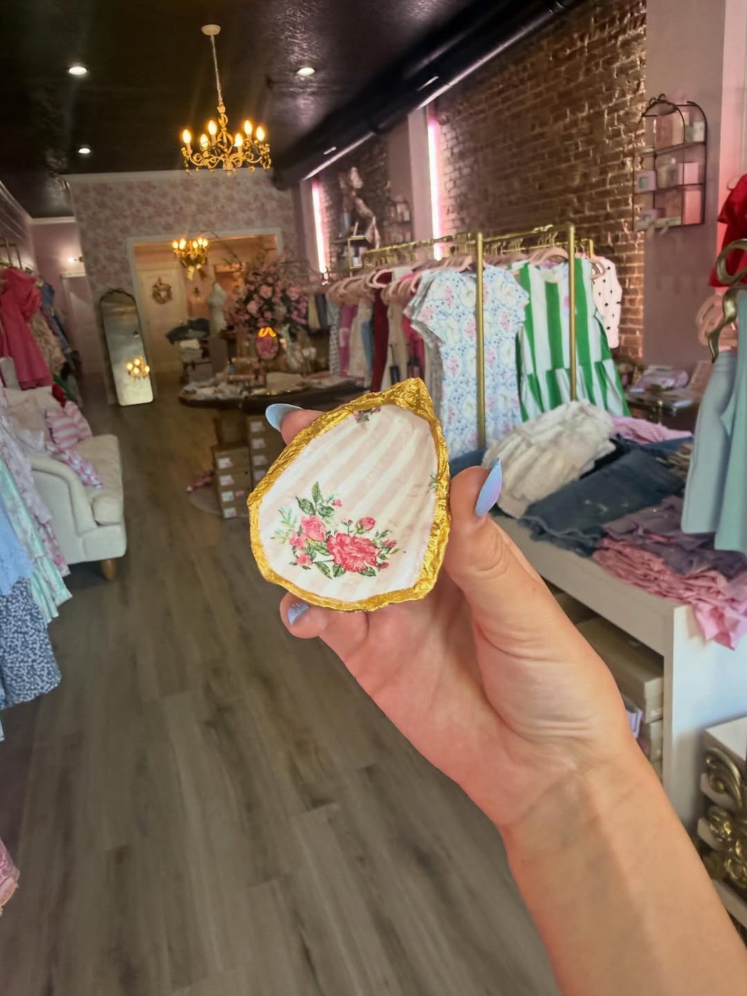 Inside Kiley's Bowtique — pink walls, brass rails, gold chandelier